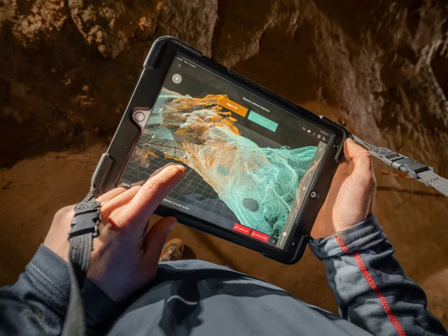 Personne utilisant une tablette pour visualiser des données 3D dans un environnement de cavité.