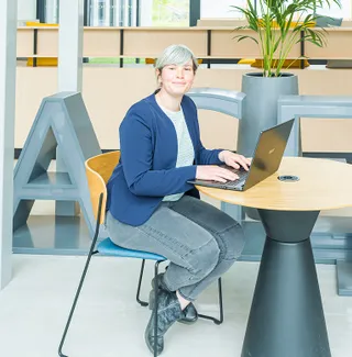 Manon, chargée de l’administration, travaillant sur un ordinateur dans un bureau.