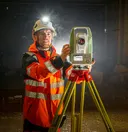 Rémi, directeur de projet, utilisant une station de mesure dans un tunnel.