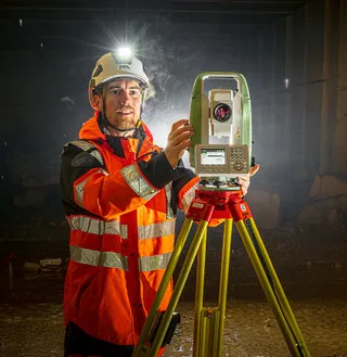 Rémi, directeur de projet, utilisant une station de mesure dans un tunnel.